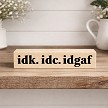 Funny desk sign that reads IDK IDC IDGAF 